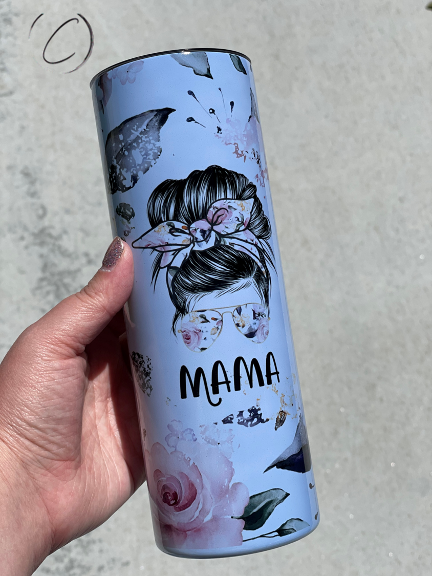 Floral Mama Messy Bun 20oz UV Blue Skinny Tumbler with a vibrant floral design and color-changing effect in sunlight.